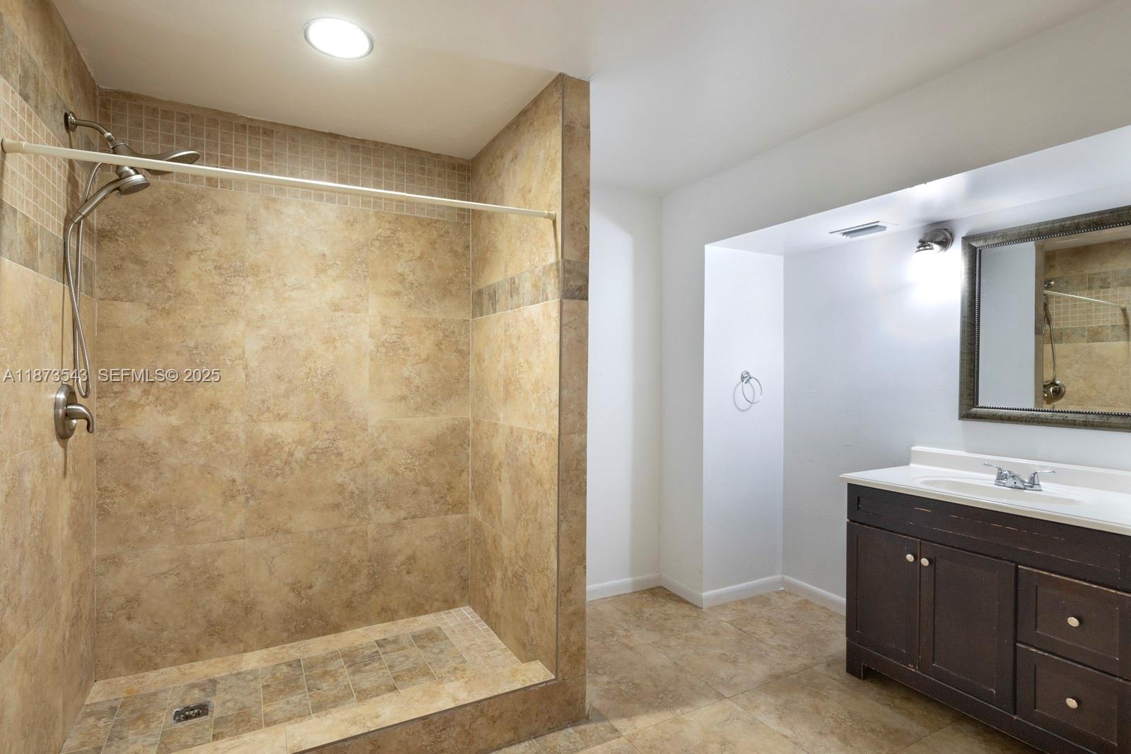 6924 Southwest 114th Place, Unit H56 Miami, FL 33173 - Photo 14 of 19 a bathroom with a shower sink vanity and mirror