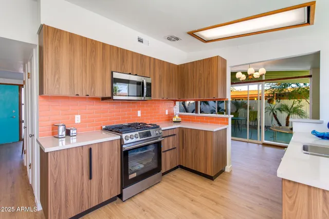 an empty room with wooden floor a ceiling fan and windows
