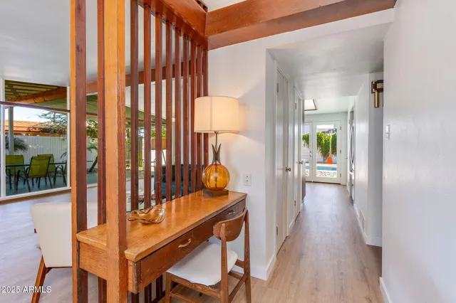a view of a hallway with dining room and wooden floor