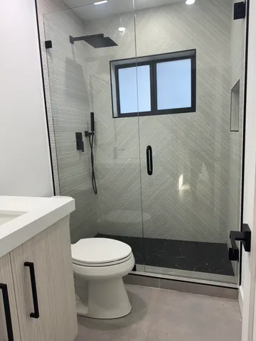 a white toilet sitting next to a bathroom sink