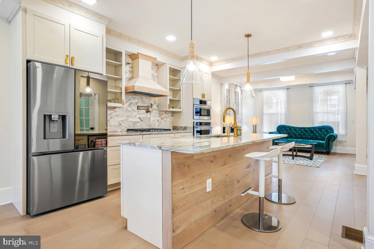 a kitchen with stainless steel appliances granite countertop a refrigerator a oven and a sink