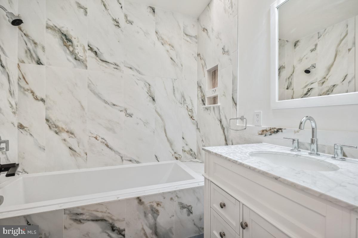 4420 15th Street Northwest Washington, DC 20011 - Photo 15 of 30 a bathroom with a granite countertop sink and a bathtub with shower