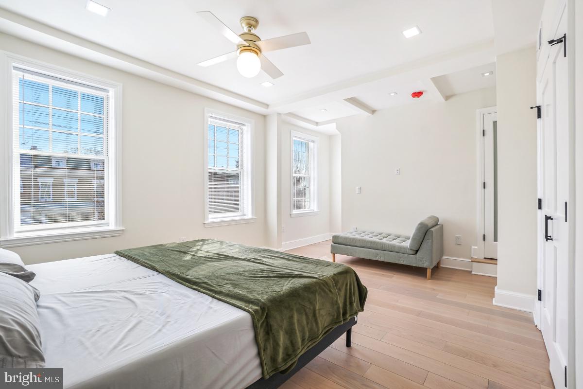 4420 15th Street Northwest Washington, DC 20011 - Photo 17 of 30 a spacious bedroom with a bed a couch and a window