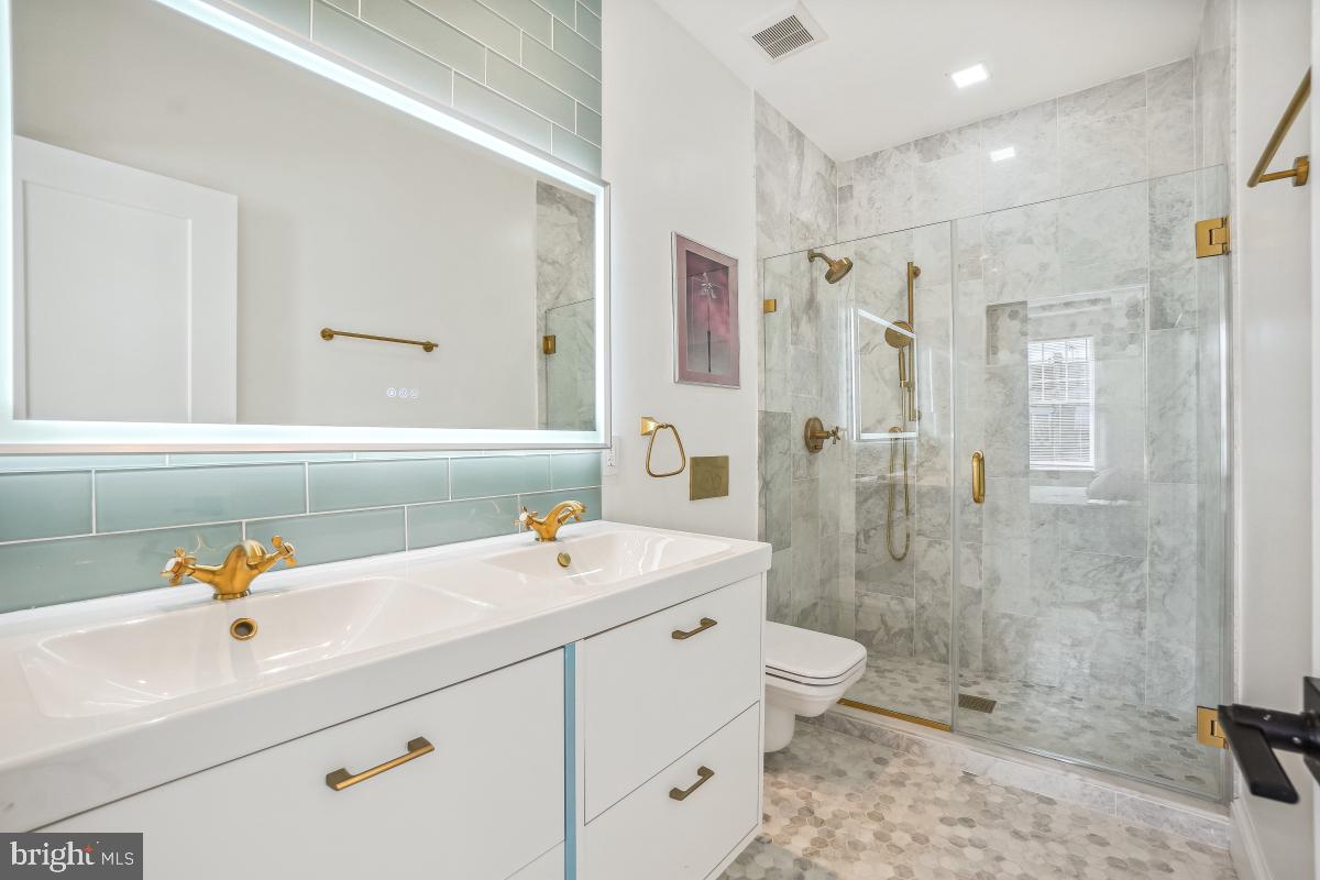 4420 15th Street Northwest Washington, DC 20011 - Photo 18 of 30 a bathroom with a double vanity sink toilet mirror and shower