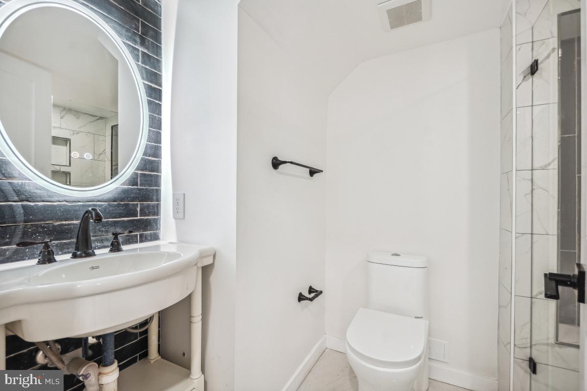 4420 15th Street Northwest Washington, DC 20011 - Photo 23 of 30 a bathroom with a sink a toilet and shower