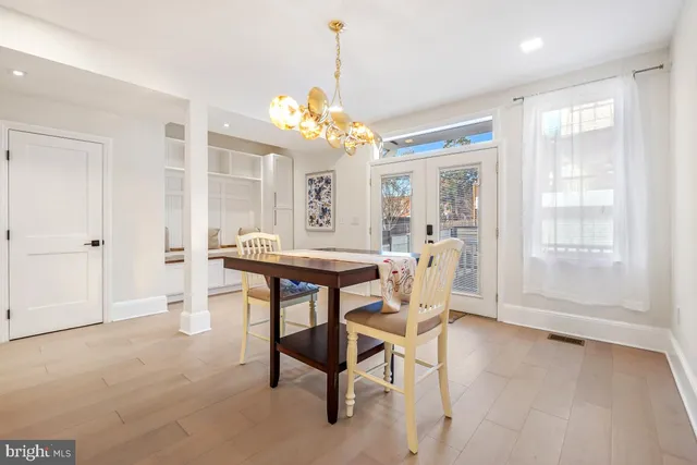 a dining room with furniture a chandelier and wooden floor