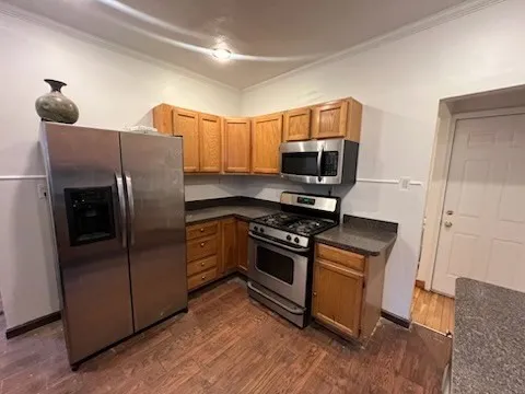 a kitchen with granite countertop a refrigerator stove and microwave