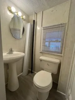 a bathroom with a sink toilet and a mirror