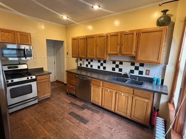 a kitchen with stainless steel appliances a stove a sink a refrigerator and cabinets