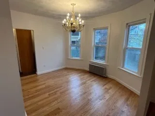 a view of a room with wooden floor and large window