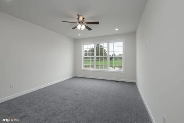 an empty room with a ceiling fan and a window