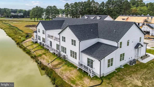 an aerial view of residential houses with yard and ocean view