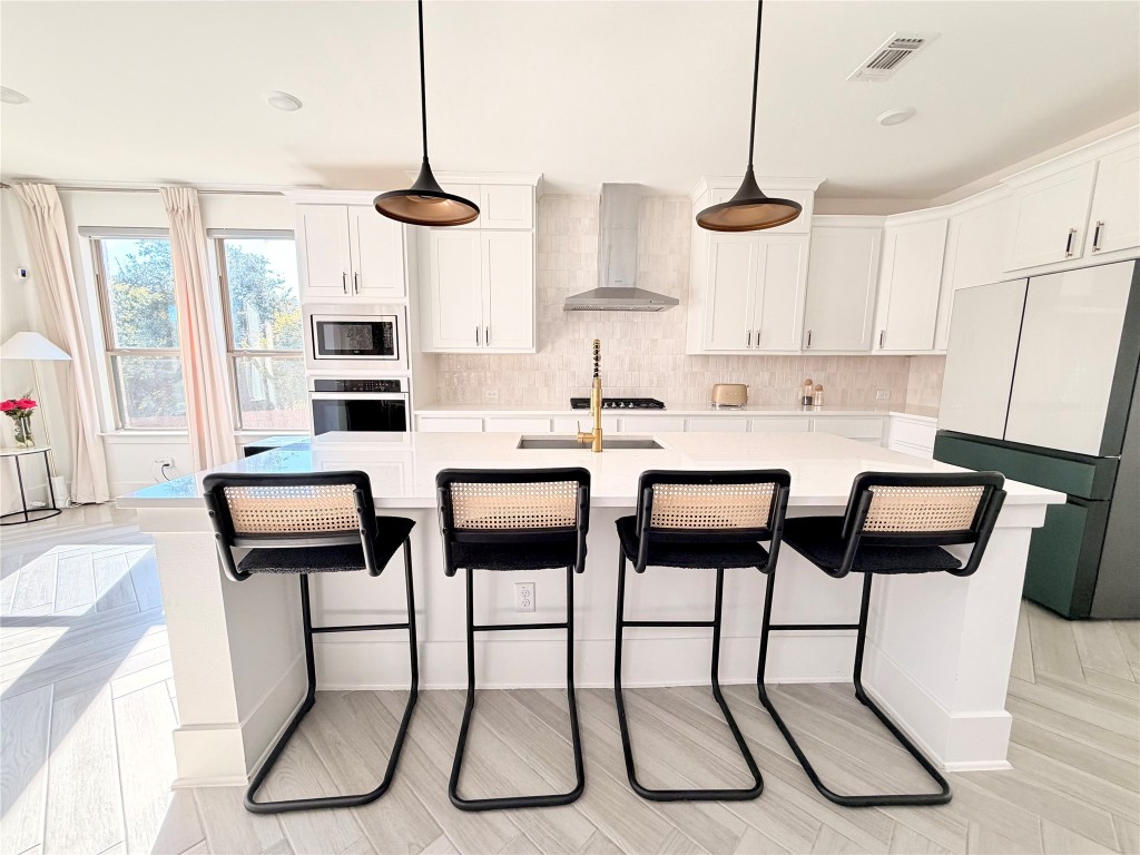 2012 Bayridge Road Georgetown, TX 78628 - Photo 8 of 32 a kitchen with stainless steel appliances kitchen island granite countertop a table chairs and white cabinets