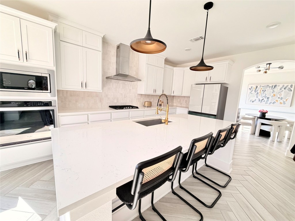 2012 Bayridge Road Georgetown, TX 78628 - Photo 10 of 32 a kitchen with stainless steel appliances kitchen island granite countertop a stove a sink and a refrigerator with wooden floor