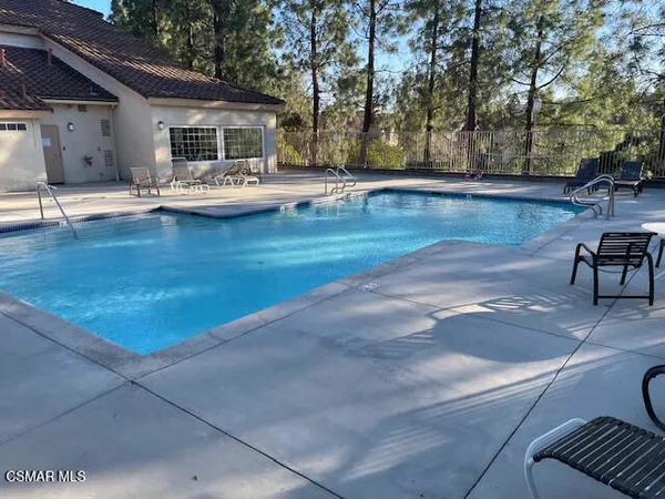 a view of a house with backyard and sitting area
