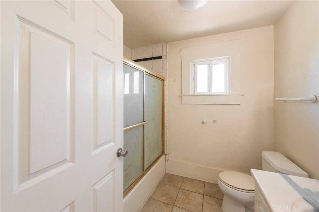 2626 5th Street Riverside, CA 92507 - Photo 14 of 31 a bathroom with a granite countertop toilet and a shower