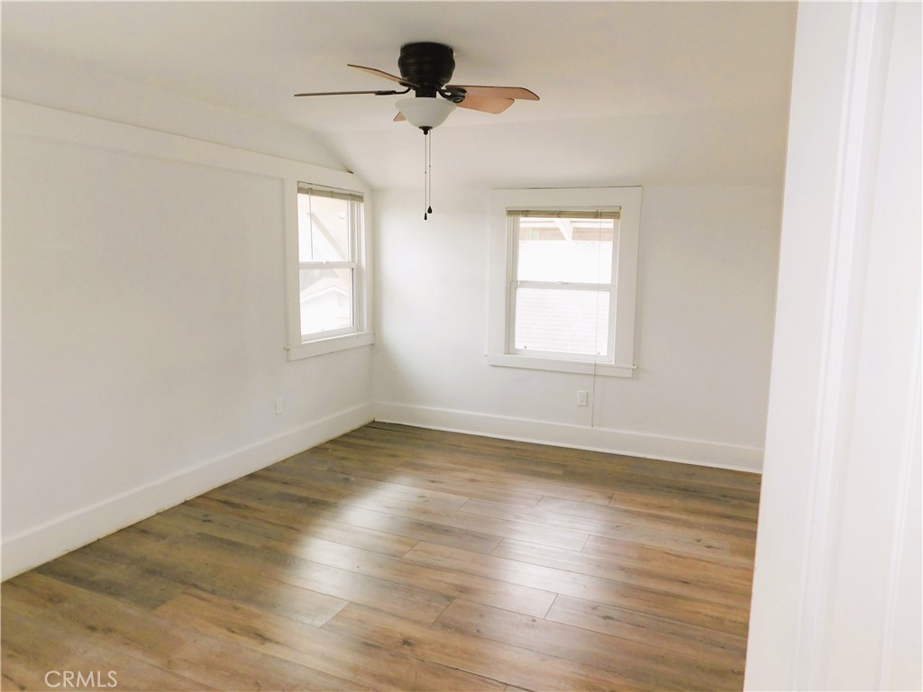 2626 5th Street Riverside, CA 92507 - Photo 21 of 31 an empty room with wooden floor chandelier fan and windows