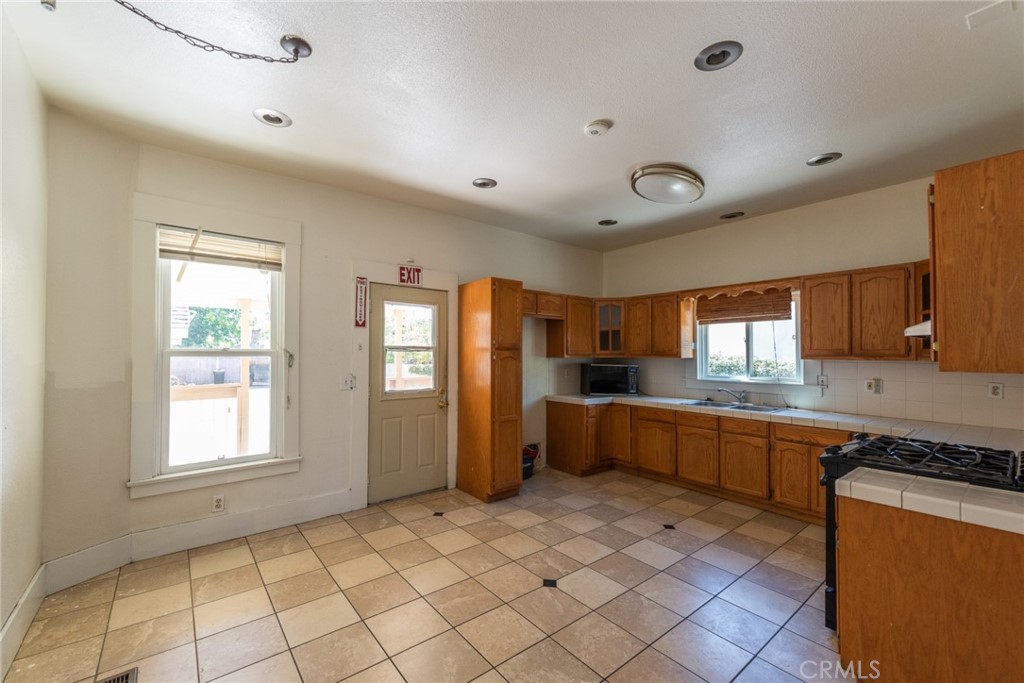 2626 5th Street Riverside, CA 92507 - Photo 7 of 31 a large kitchen with a window and stainless steel appliances