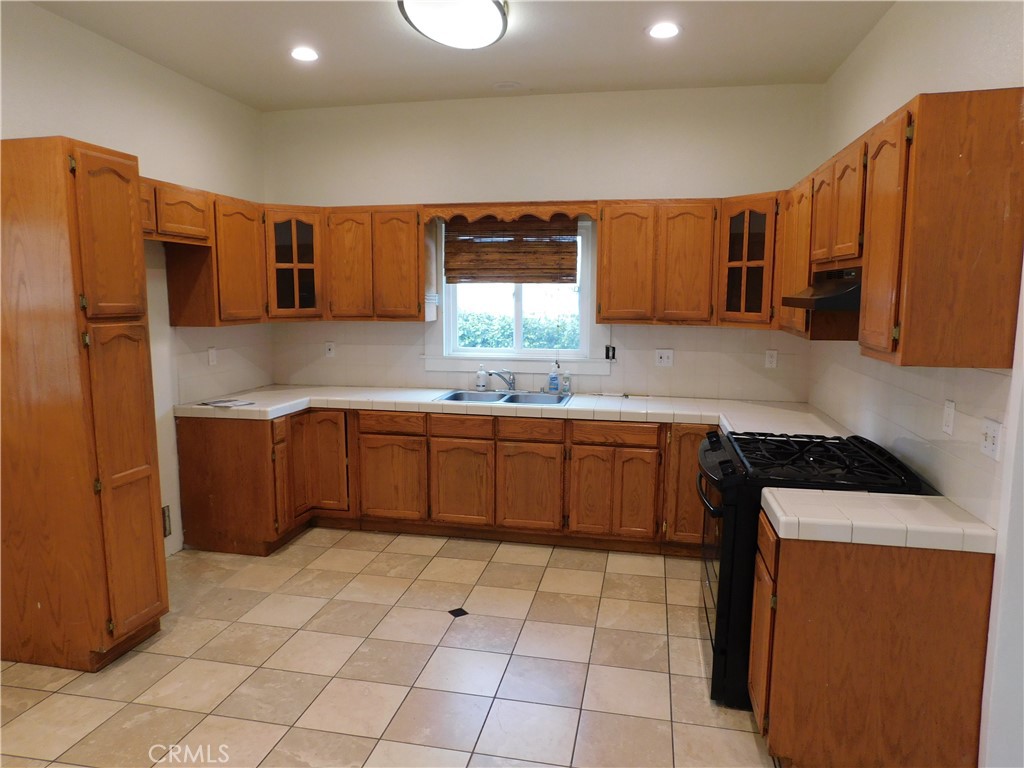 2626 5th Street Riverside, CA 92507 - Photo 9 of 31 a kitchen with stainless steel appliances a sink a stove a refrigerator cabinets and a window