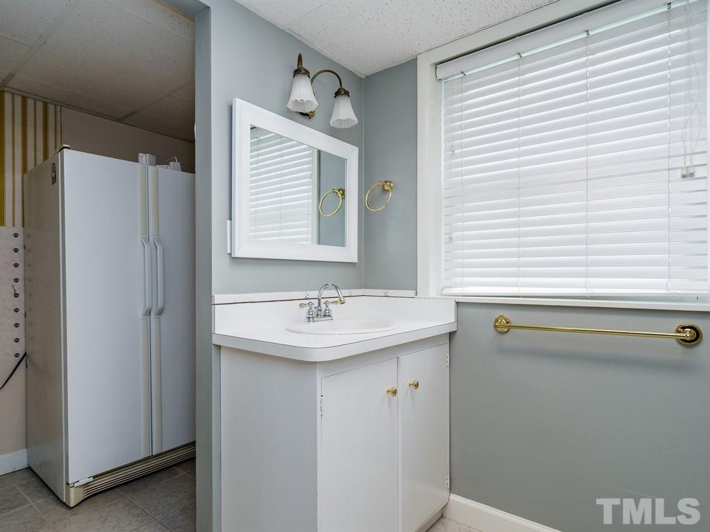2456 Oxford Road Raleigh, NC 27608 - Photo 22 of 30 a bathroom with a sink a mirror and a window