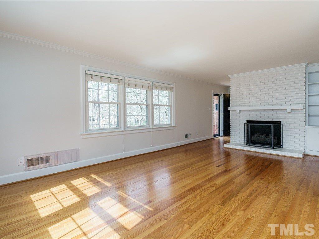 2456 Oxford Road Raleigh, NC 27608 - Photo 4 of 30 a view of empty room with wooden floor and fireplace