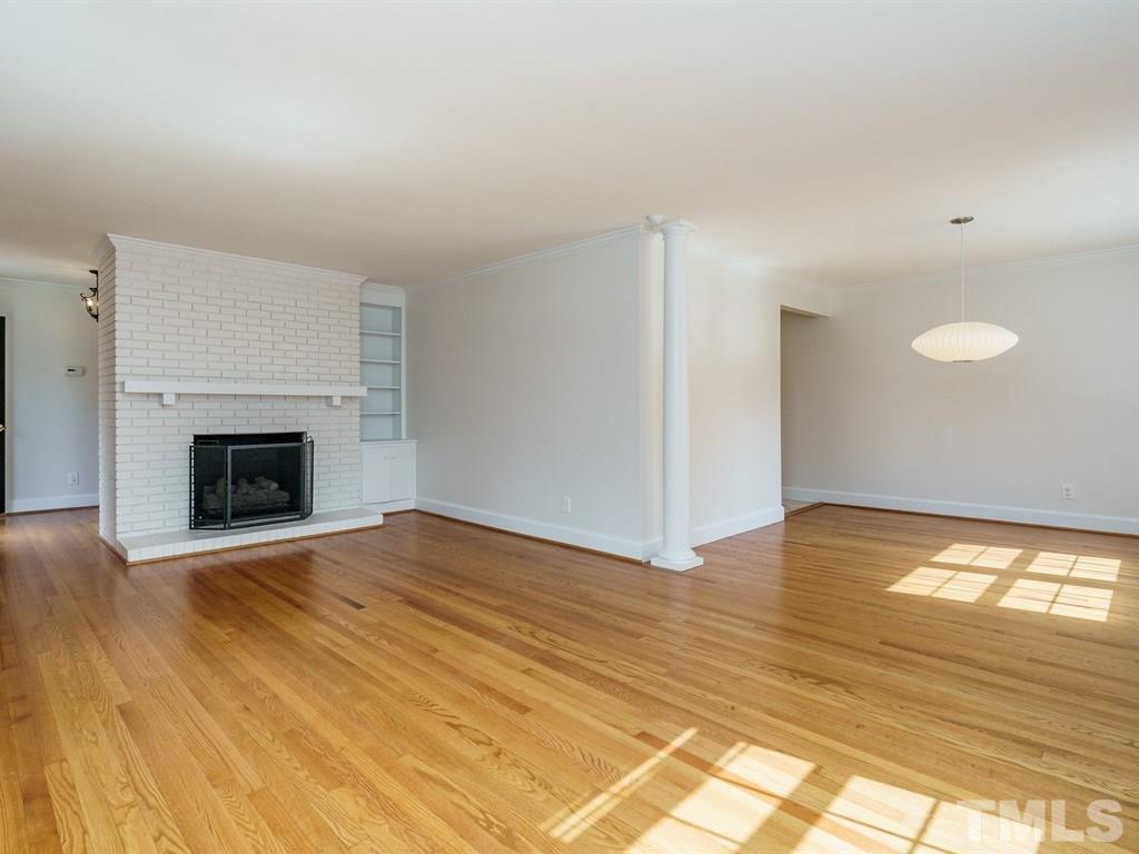 2456 Oxford Road Raleigh, NC 27608 - Photo 5 of 30 a view of empty room with wooden floor and fireplace