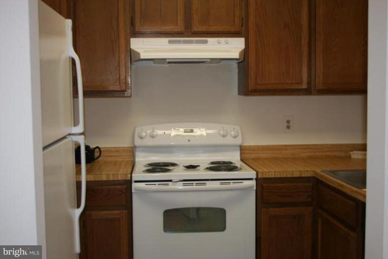 7820 Harrowgate Circle, Unit 105 Springfield, VA 22152 - Photo 11 of 11 a kitchen with a stove and a microwave
