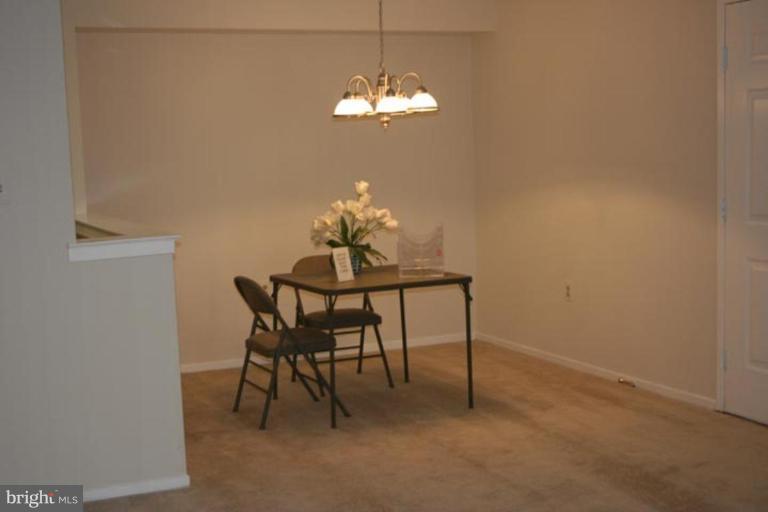 7820 Harrowgate Circle, Unit 105 Springfield, VA 22152 - Photo 3 of 11 a dining room with furniture and chandelier