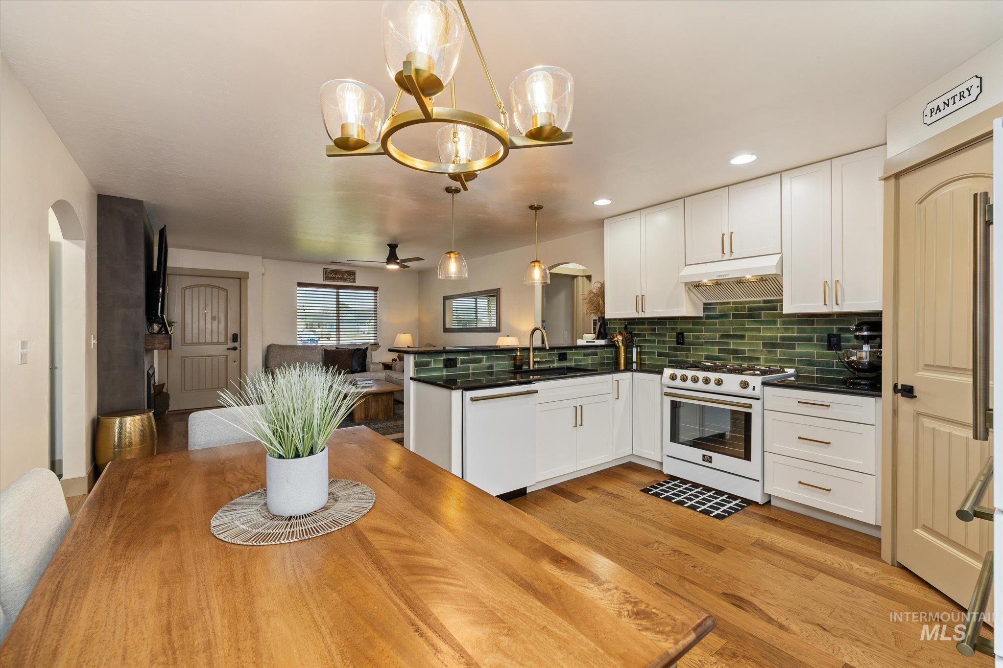 1065 West 11th Street Weiser, ID 83672 - Photo 19 of 48 Kitchen with arched walkways, a peninsula, white cabinetry, and range with gas stovetop