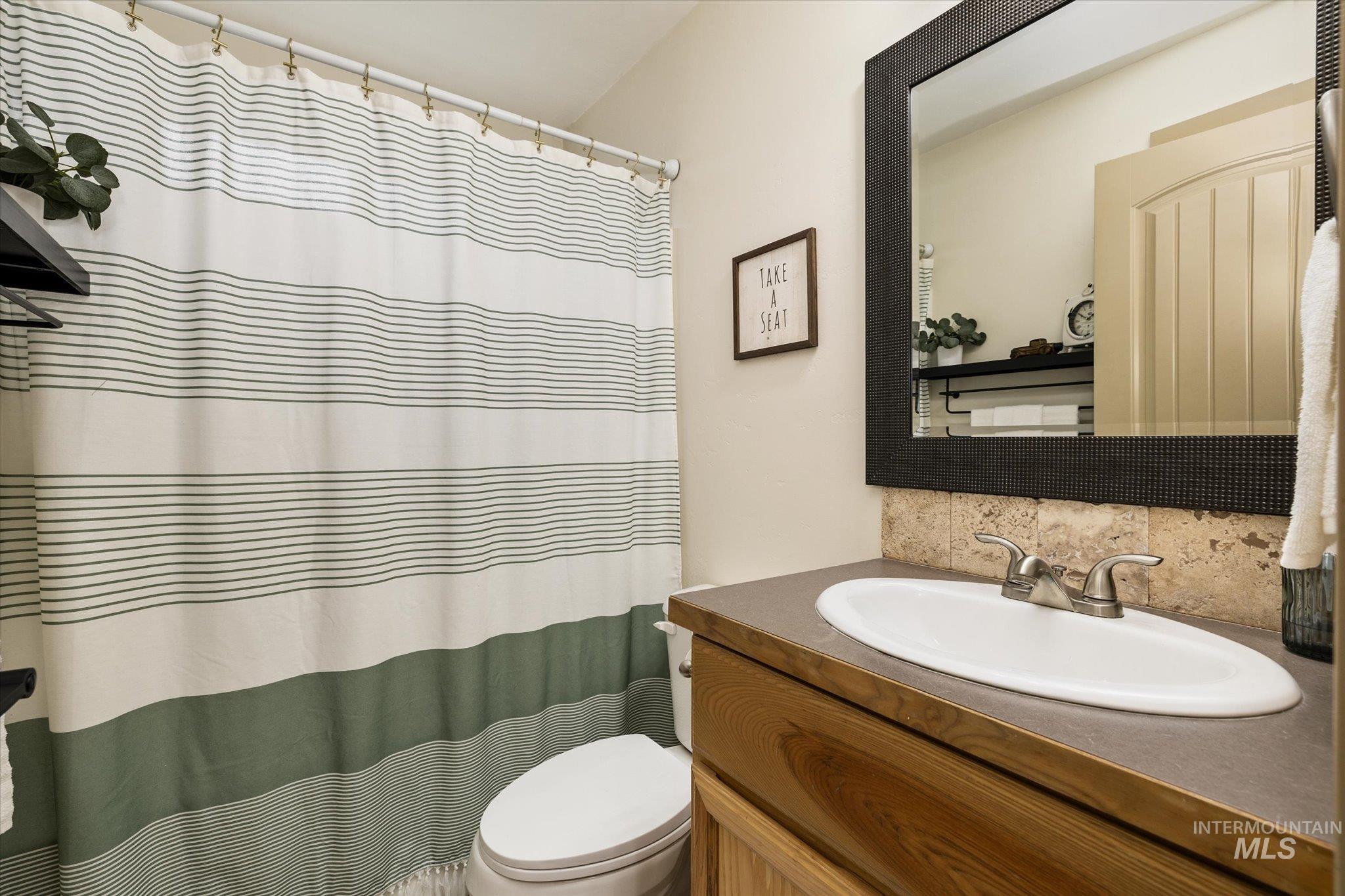 1065 West 11th Street Weiser, ID 83672 - Photo 38 of 48 Full bath with vanity, curtained shower, and tasteful backsplash
