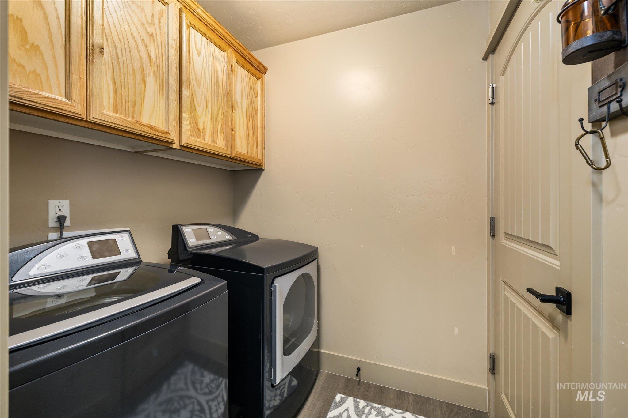 1065 West 11th Street Weiser, ID 83672 - Photo 40 of 48 Laundry area featuring cabinet space, dark wood-style flooring, and washer and dryer