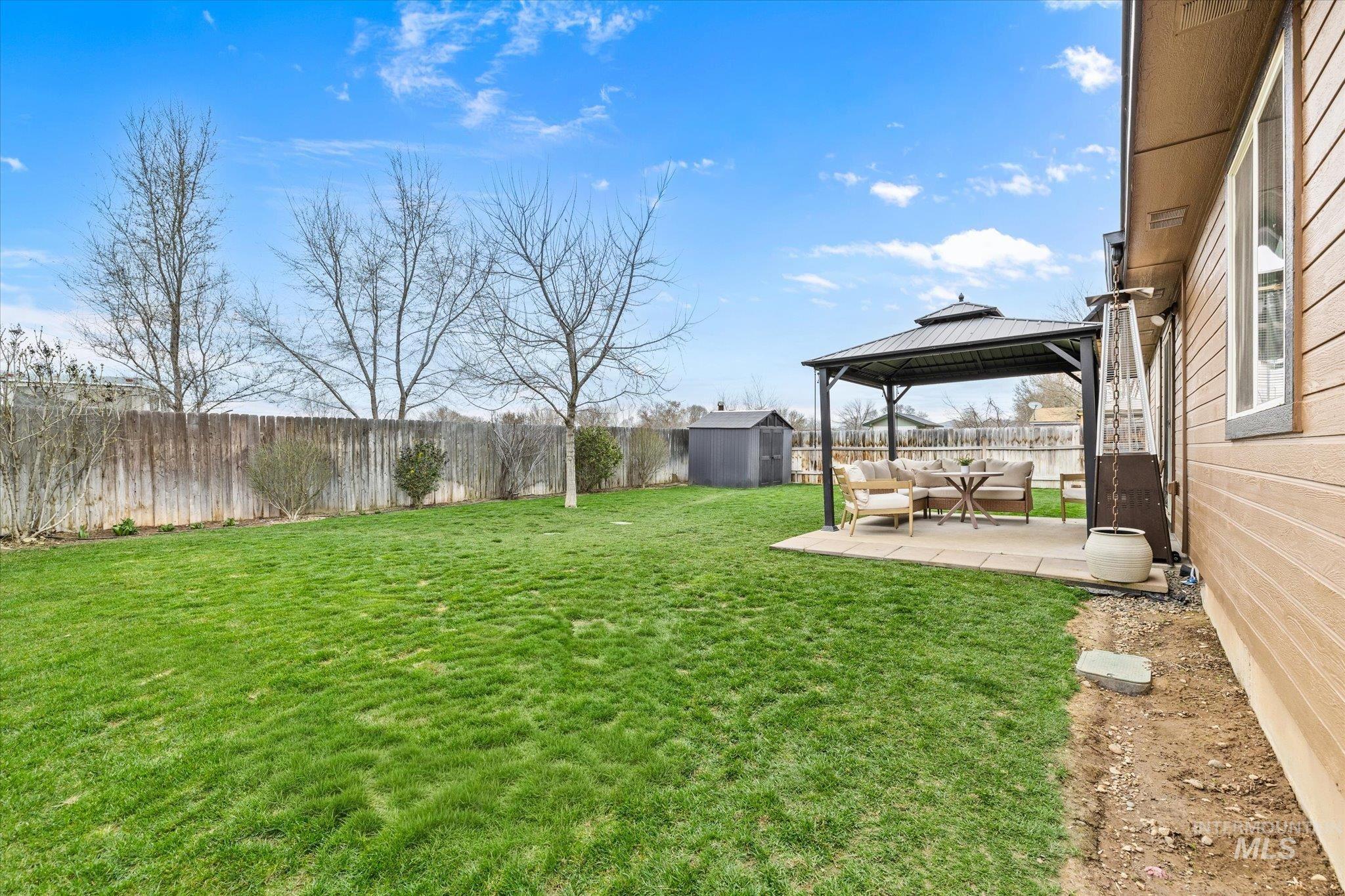 1065 West 11th Street Weiser, ID 83672 - Photo 43 of 48 Fenced backyard with a patio area, a gazebo, a storage unit, and an outdoor lounge area