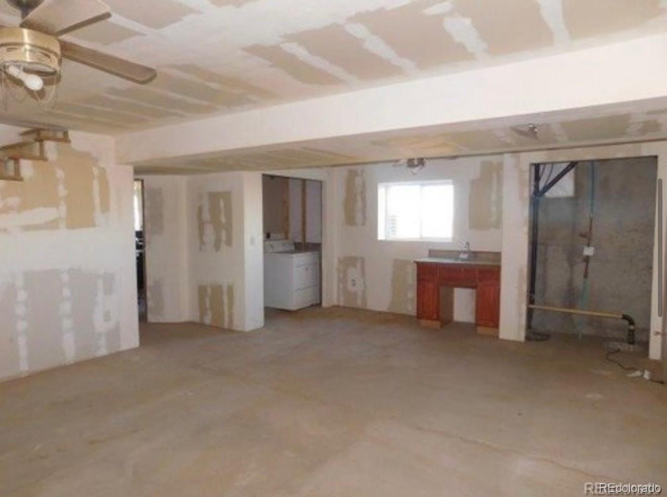 38423 County Road 166 Agate, CO 80101 - Photo 10 of 28 an empty room with a fireplace and windows