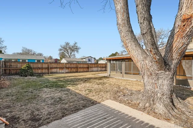 a view of a house with backyard and trees