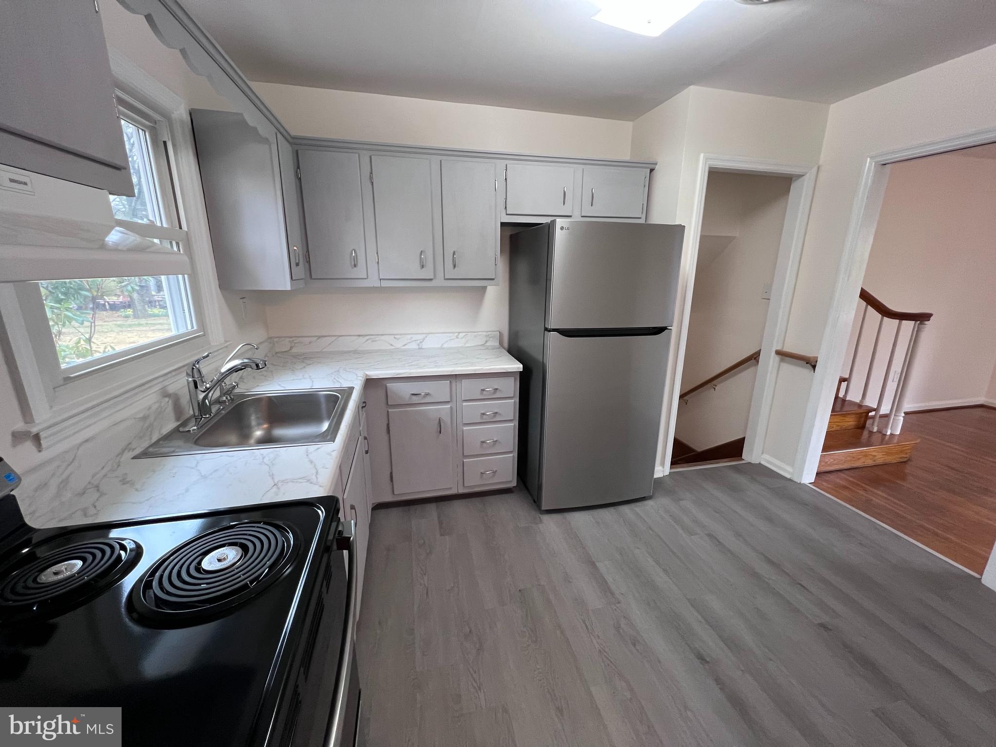 155 Sillery Bay Road Pasadena, MD 21122 - Photo 12 of 34 a kitchen with a refrigerator a sink and wooden floor