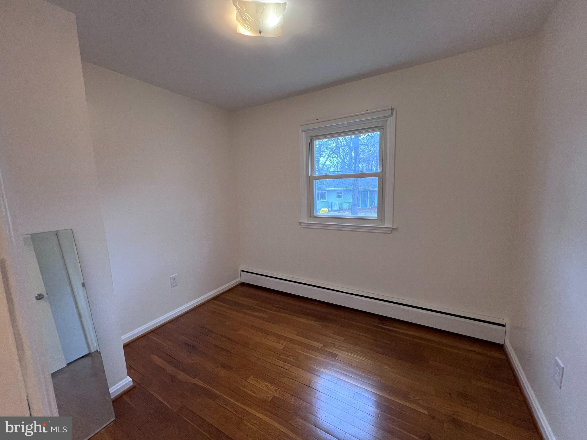 155 Sillery Bay Road Pasadena, MD 21122 - Photo 16 of 34 an empty room with wooden floor and windows