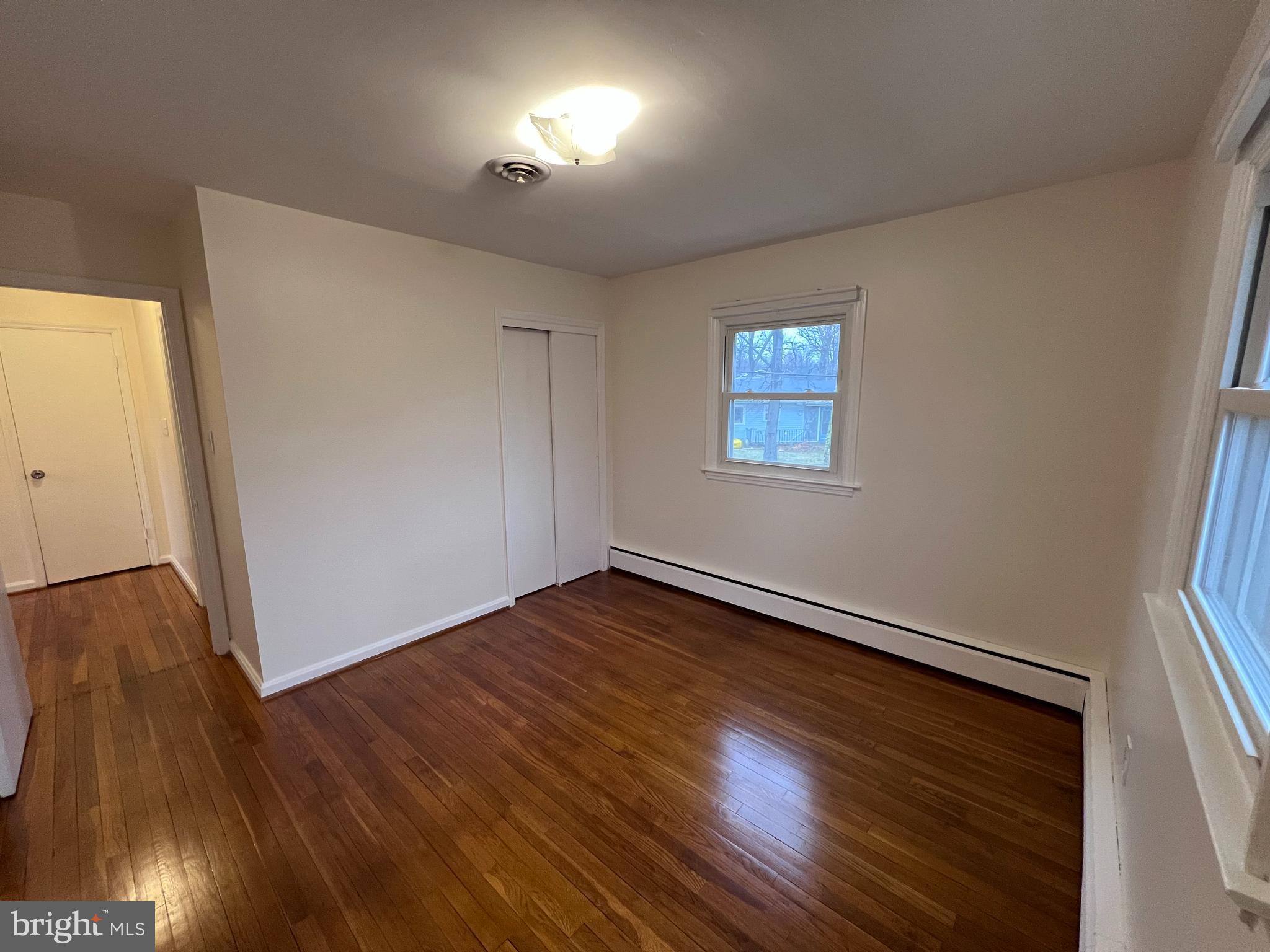 155 Sillery Bay Road Pasadena, MD 21122 - Photo 19 of 34 an empty room with wooden floor and windows