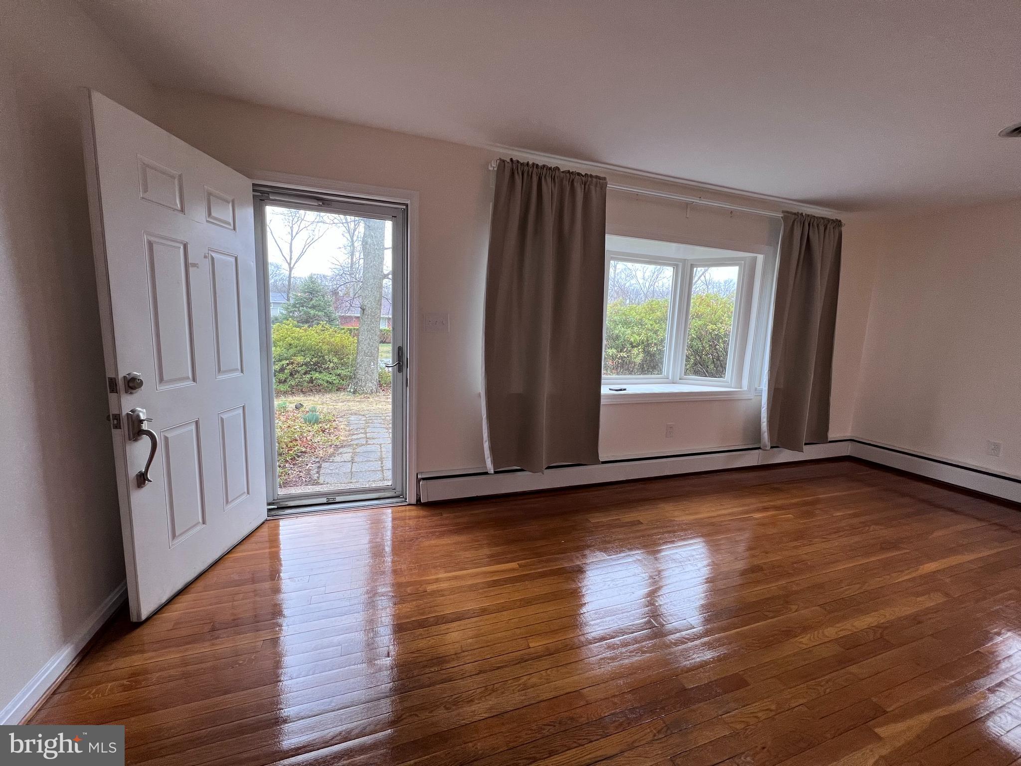155 Sillery Bay Road Pasadena, MD 21122 - Photo 4 of 34 a view of an empty room with wooden floor and a window
