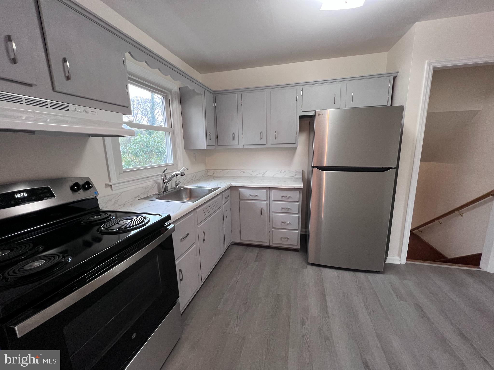 155 Sillery Bay Road Pasadena, MD 21122 - Photo 9 of 34 a kitchen with a refrigerator sink and cabinets