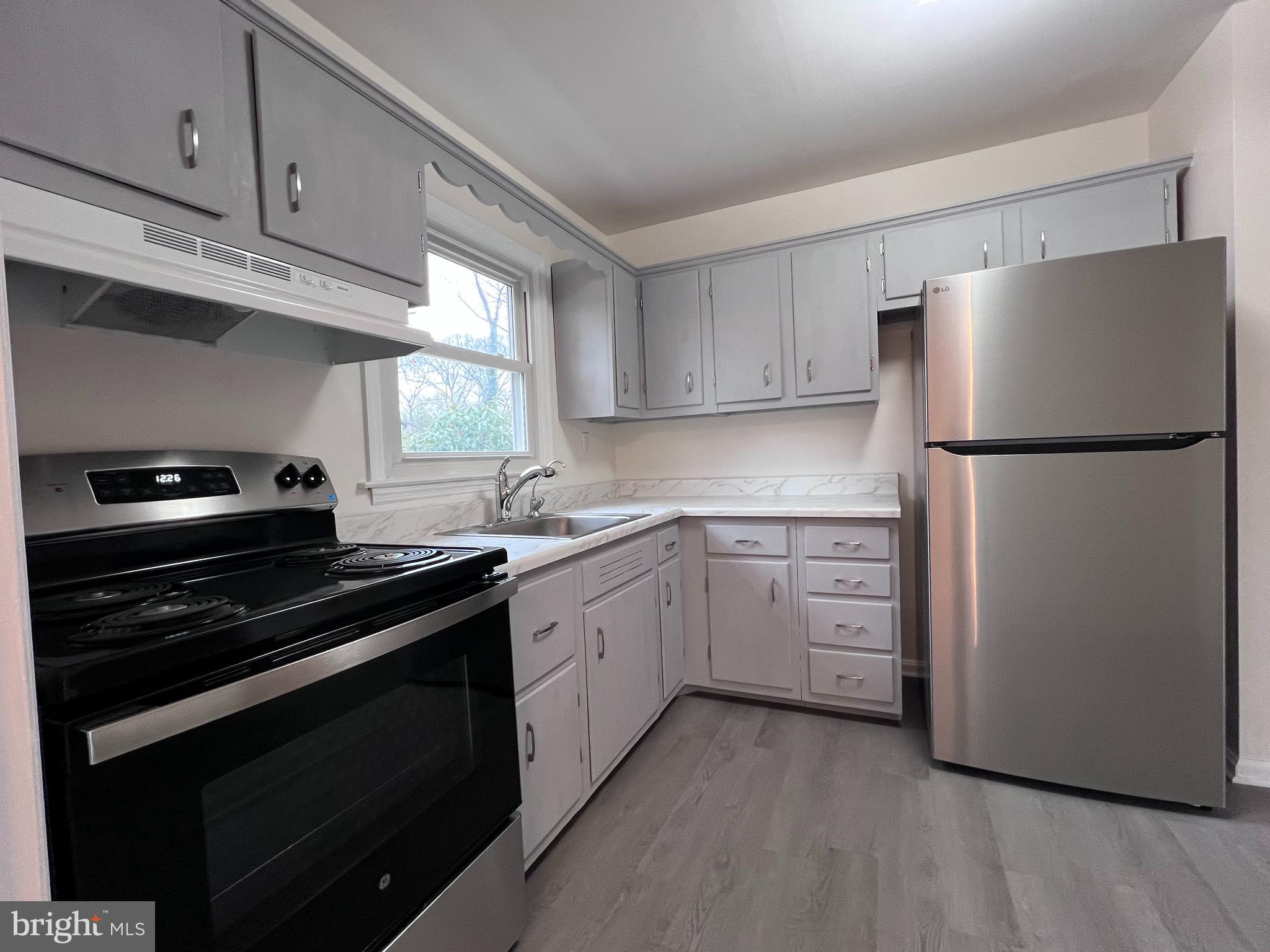 155 Sillery Bay Road Pasadena, MD 21122 - Photo 10 of 34 a kitchen with cabinets appliances a sink and a window