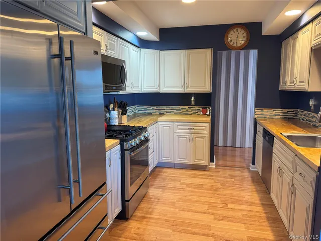 a kitchen with stainless steel appliances granite countertop a refrigerator a stove top oven a sink and dishwasher