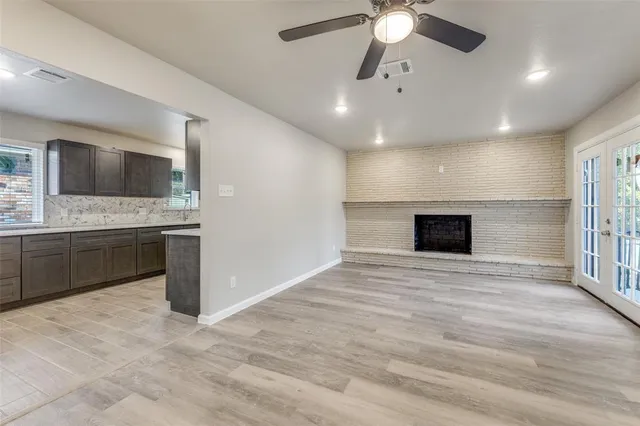 a view of an empty room with a kitchen and a window