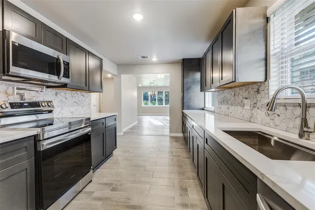 a kitchen with stainless steel appliances granite countertop a sink and stove top oven