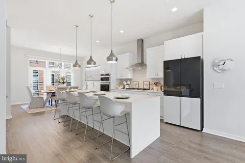 a large white kitchen with a large window and stainless steel appliances
