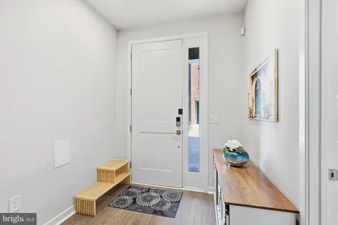 a view of a hallway with wooden floor and entryway
