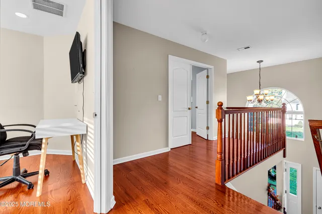 a view of hallway with furniture and wooden floor