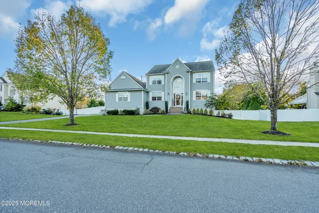 a view of a house with a big yard and large trees
