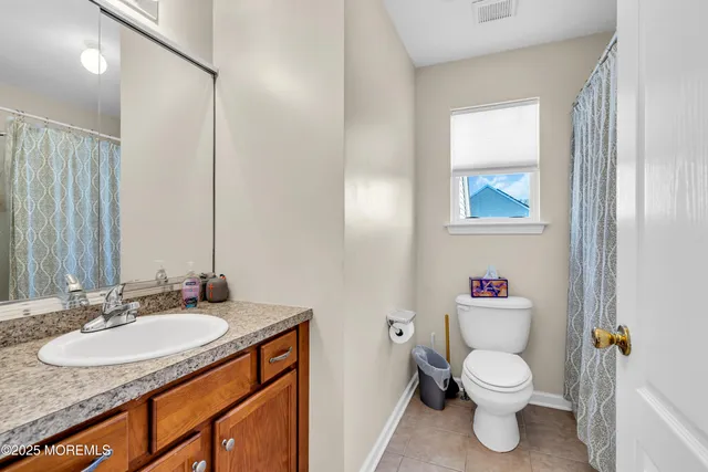a bathroom with a granite countertop sink toilet and a mirror