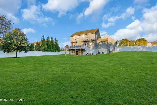 a view of a house with a big yard and large trees