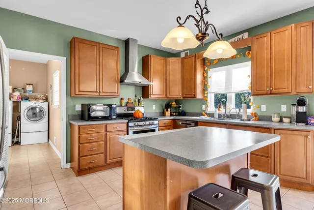 a kitchen with stainless steel appliances granite countertop a sink dishwasher stove and refrigerator with wooden floor